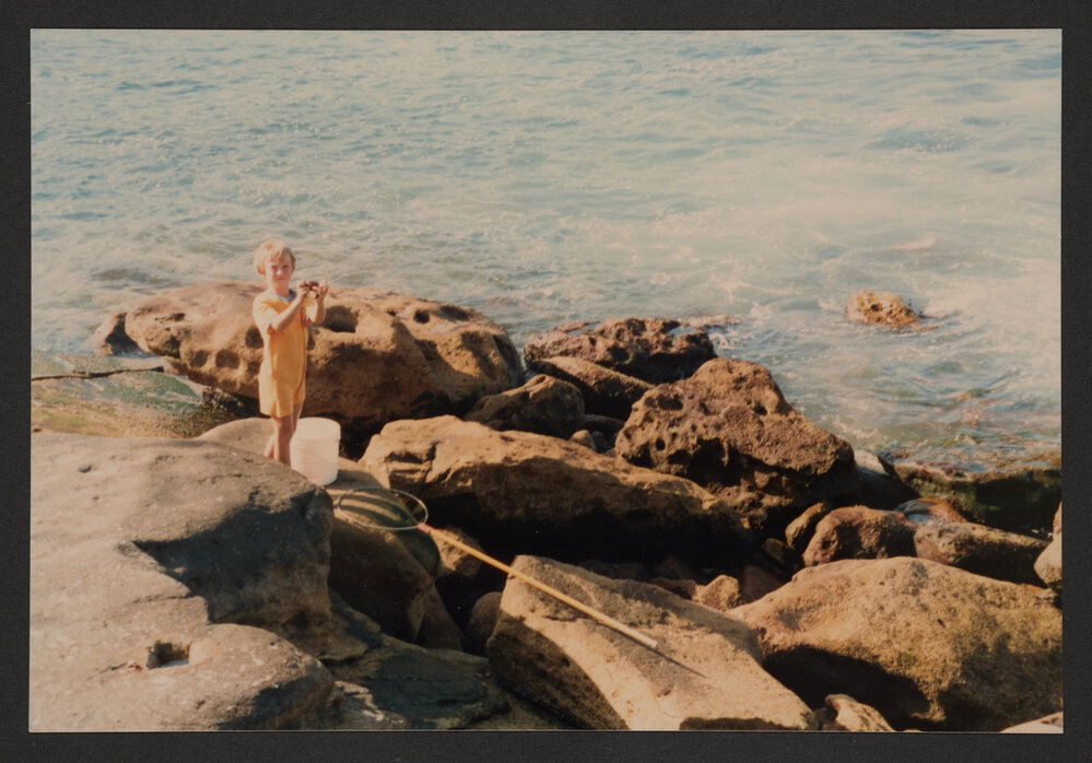 Bronte beach, Small boy at bogey hole fishing for crabs.