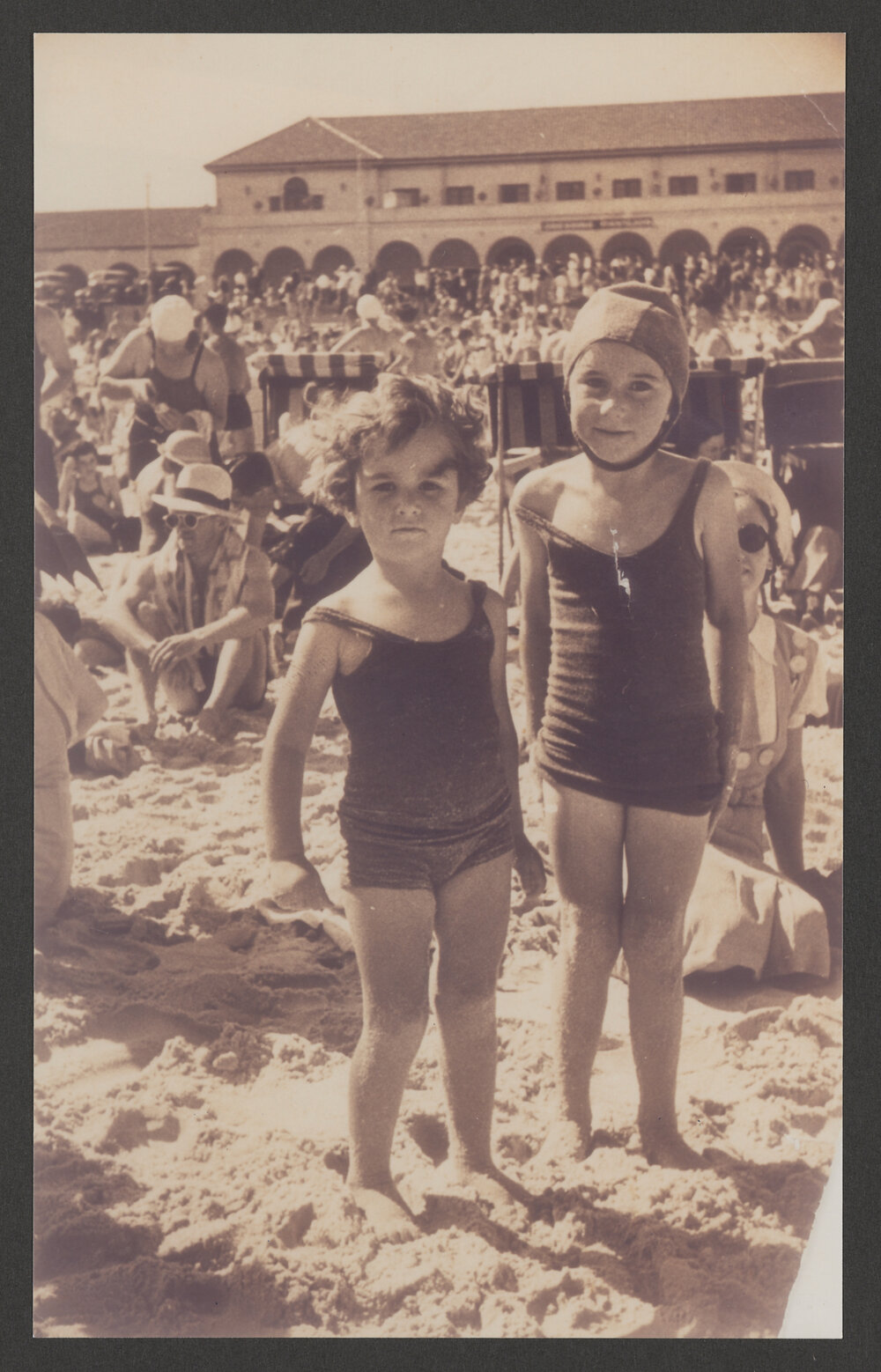 Joan Moseatt ( mother Norah is seated behind) Lee Moseatt in bathing cap at Bondi beach, (woollen costumes).
